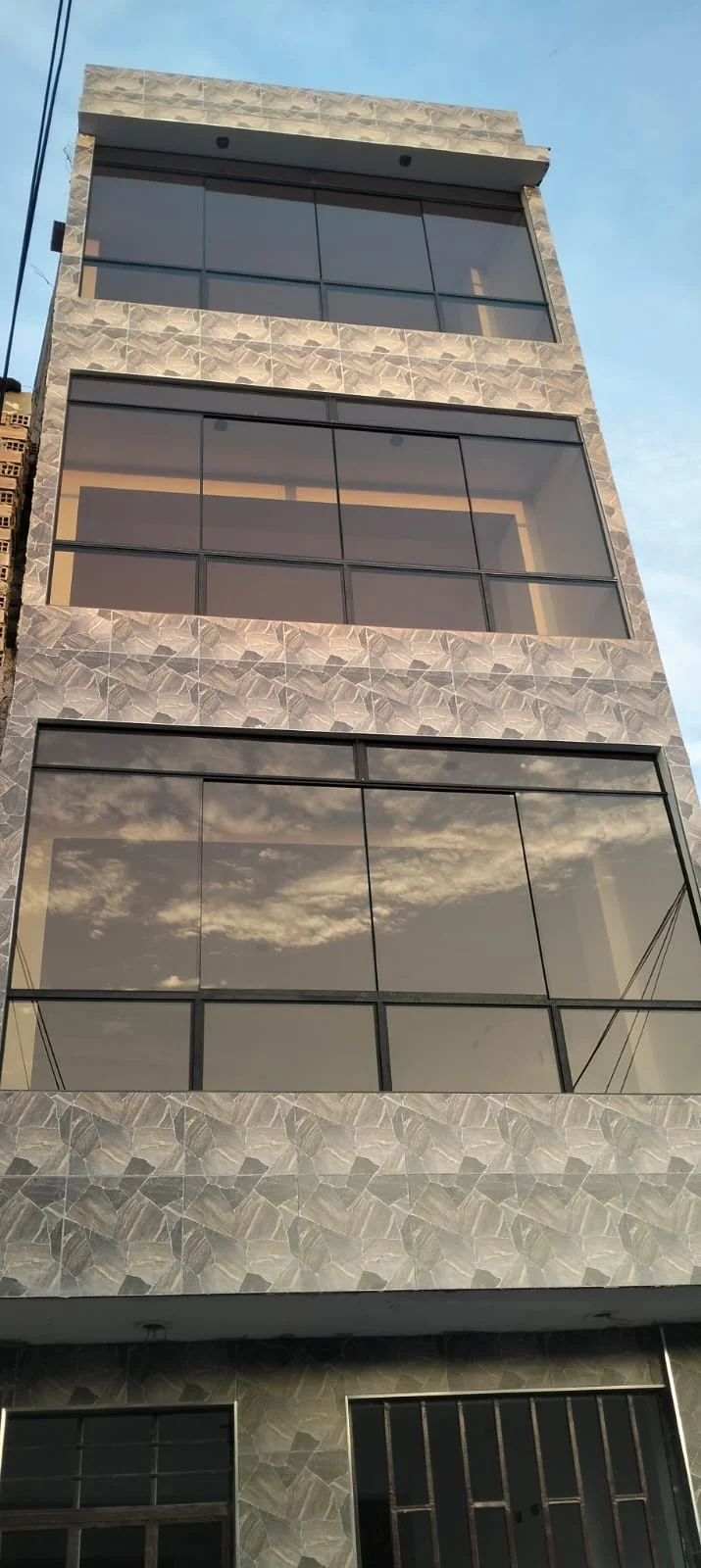 Ventanas con dos fijos y dos corredizos, vidrio bronce de 6 mm, en casa angosta de 4 pisos