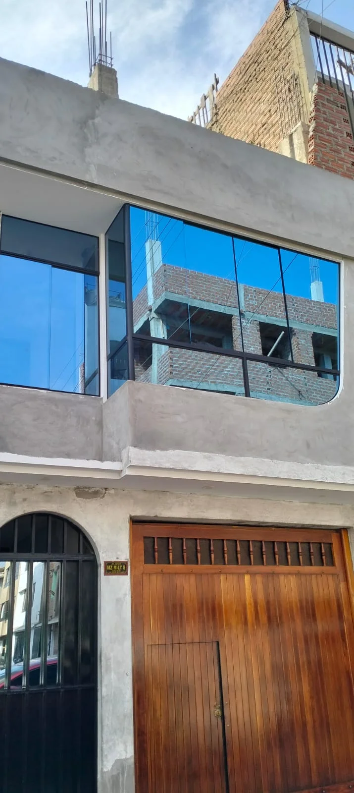 Ventanas en sistema Nova con vidrio reflejante azul cielo para control de temperatura